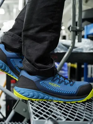 Safety shoes on a steel grate in an industrial setting