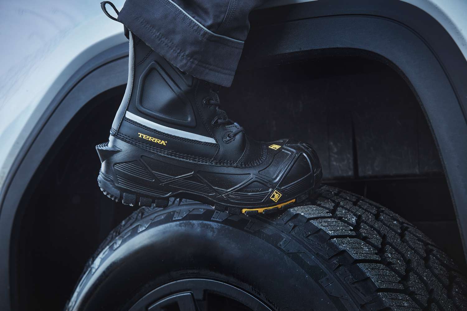 Terra Crossbow 777 pac boot stepping up onto a truck tire in the snow