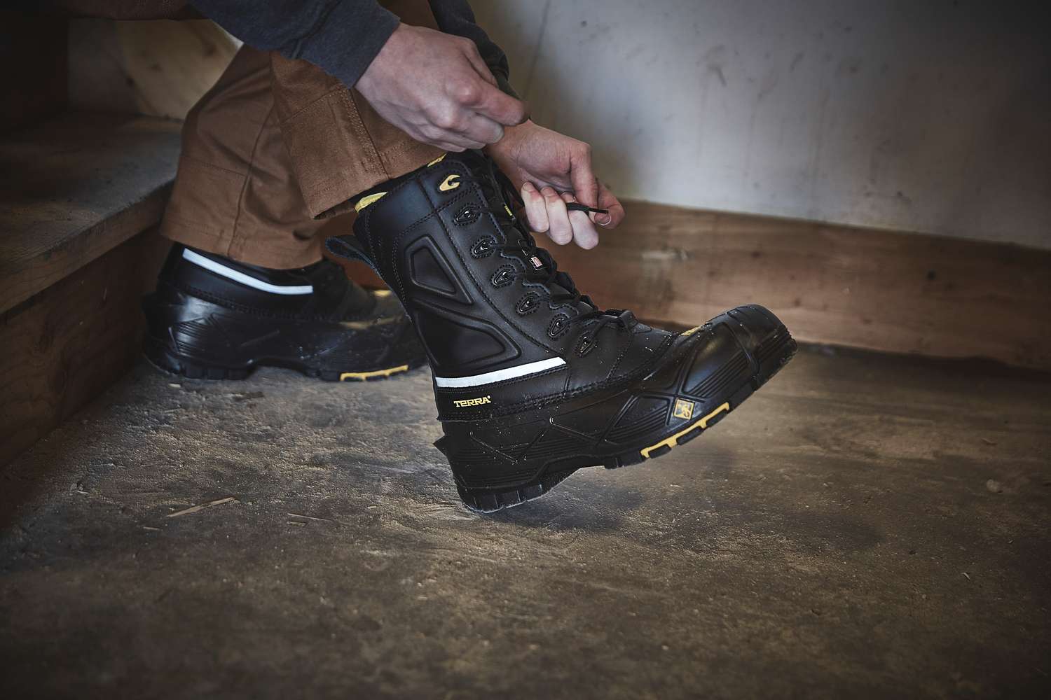 Pulling on Terra Crossbow 777 pac boots in a work shop