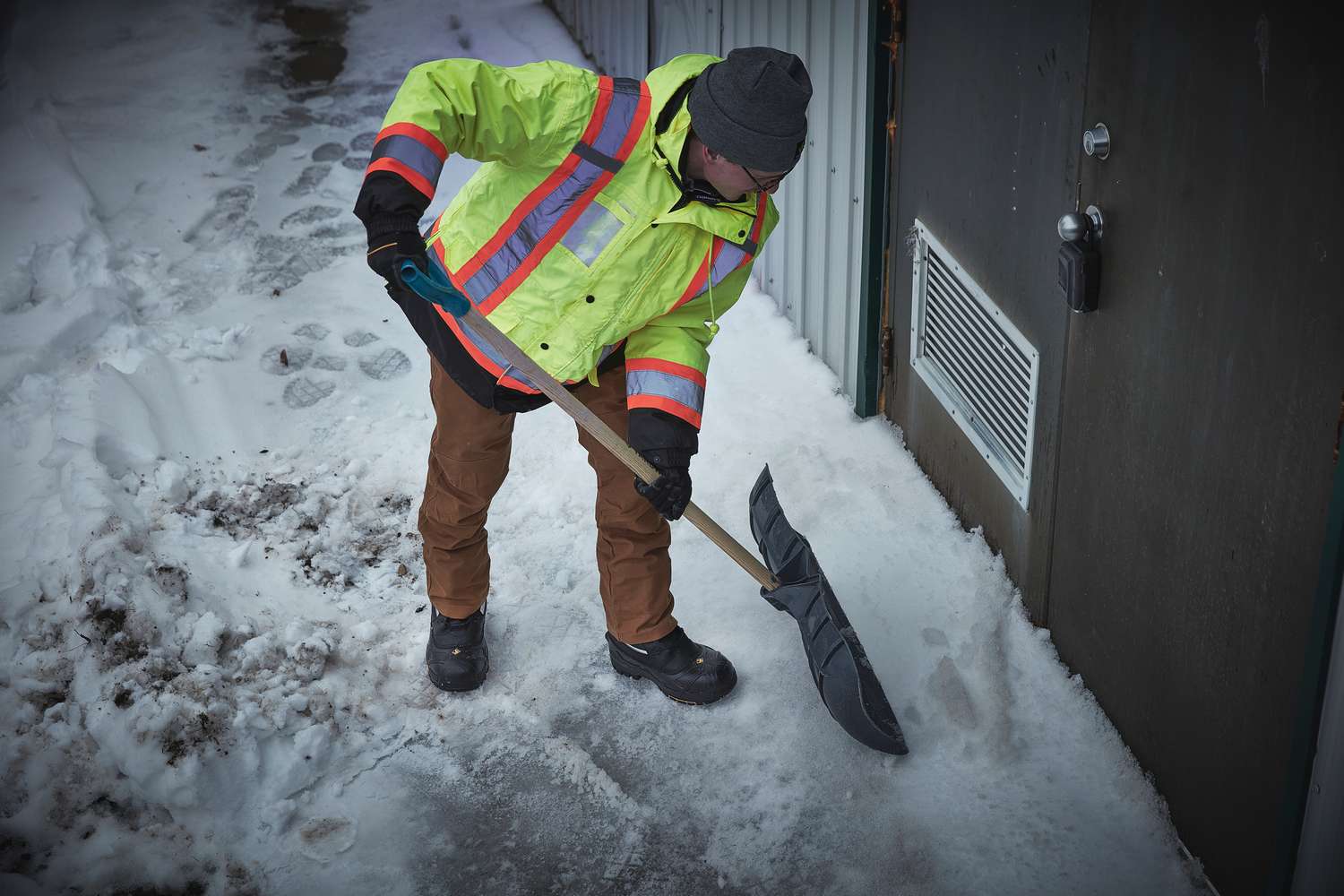 A worker in hi-vis gear clearing snow in Terra Crossbow 777 boots
