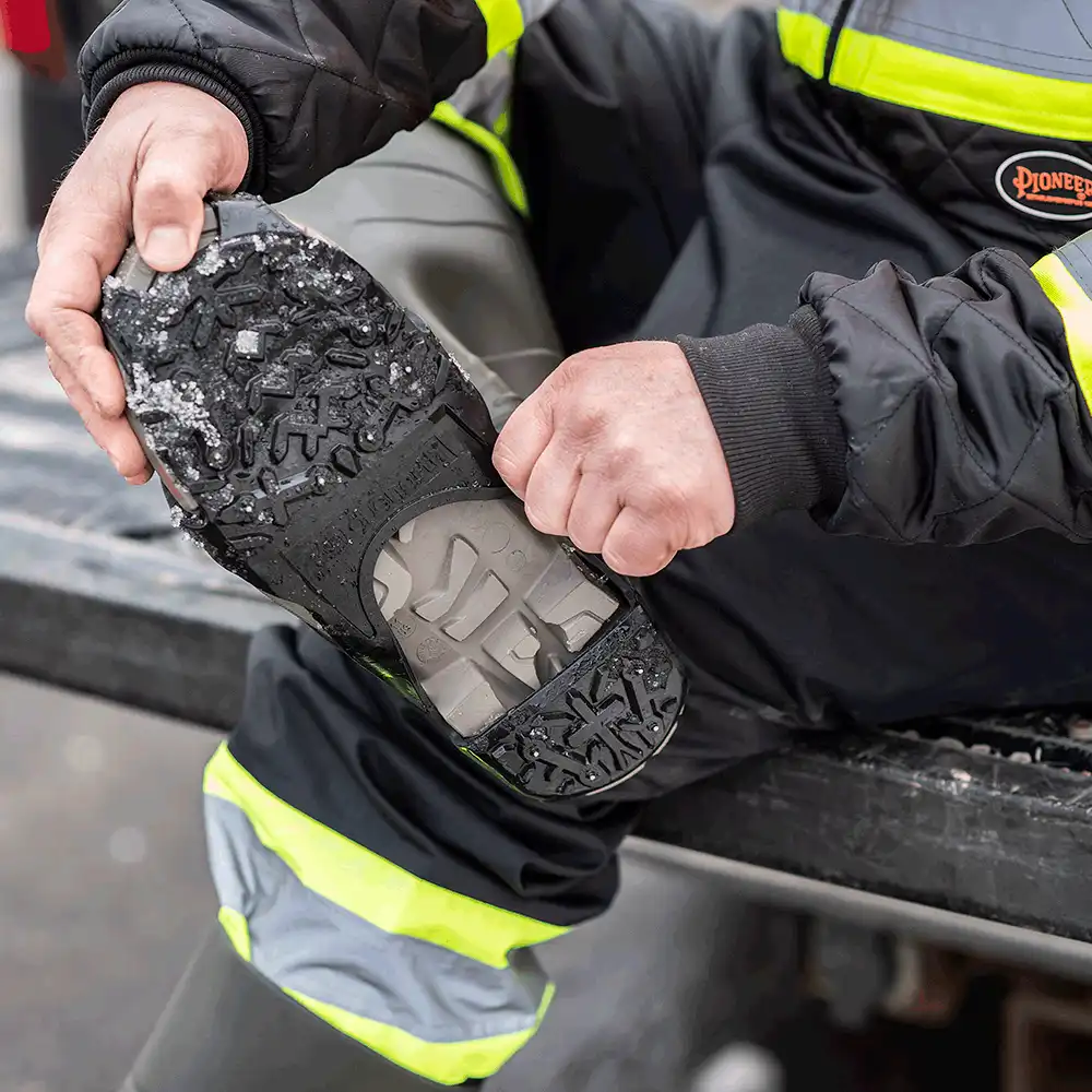 Pulling a DueNorth Heavy Duty traction aid onto a boot